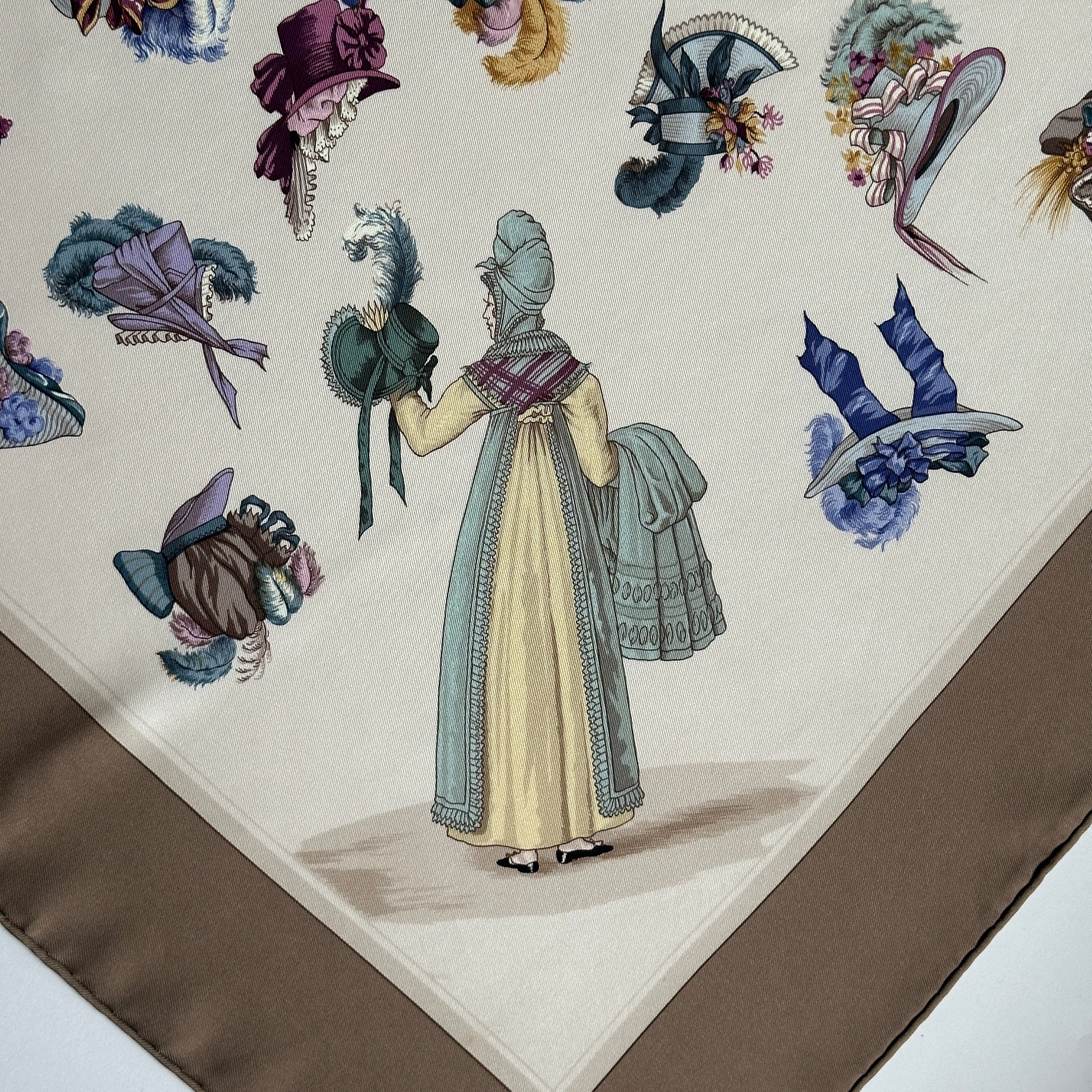 Illustration d'une femme en robe XIXème siècle vue de dos tenant un chapeau vert, entourée de bonnets volants sur fond soie crème.