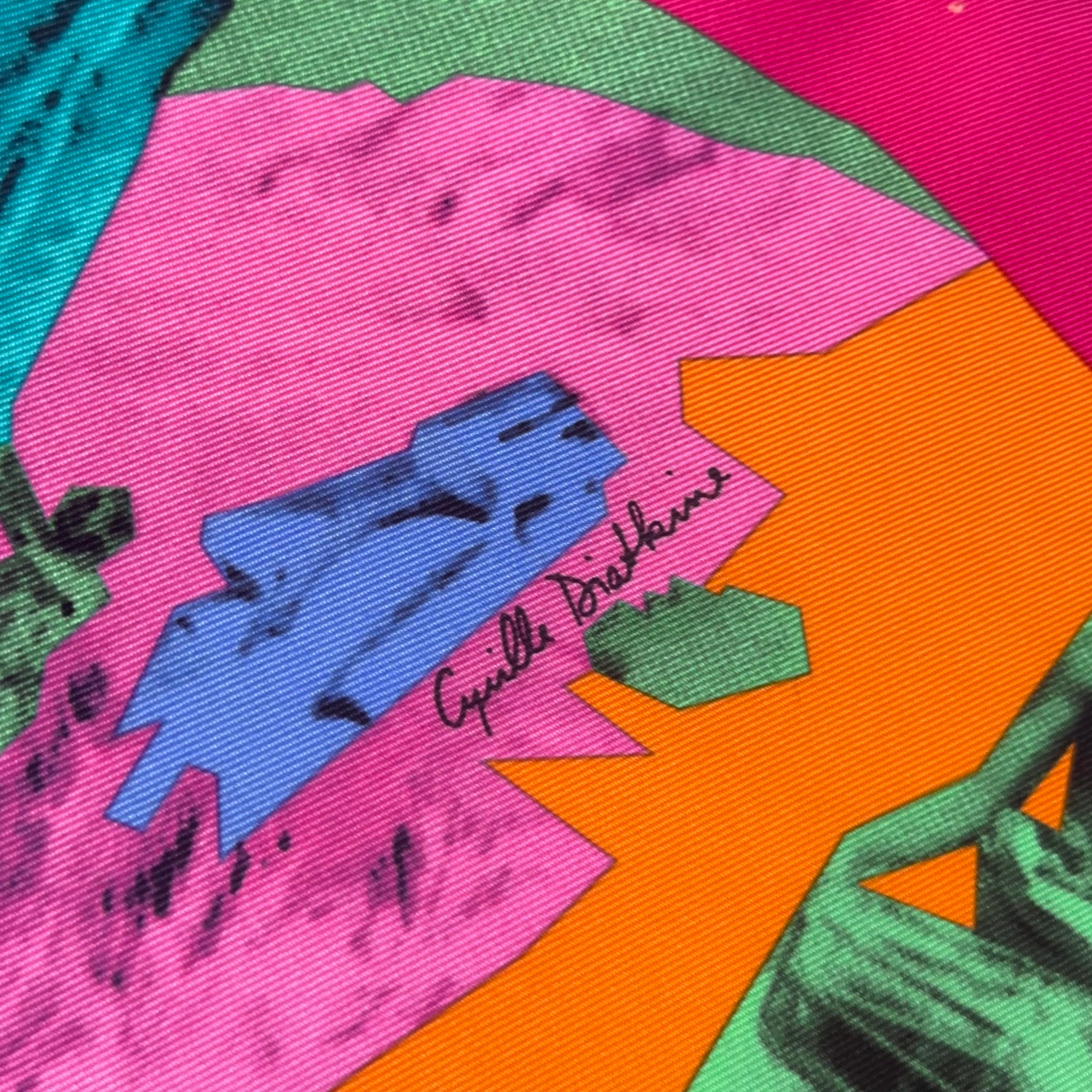 Zoom sur la signature de l'artiste "Cyrille Diatkine" discrètement intégrée dans les formes géométriques roses et oranges du dessin.